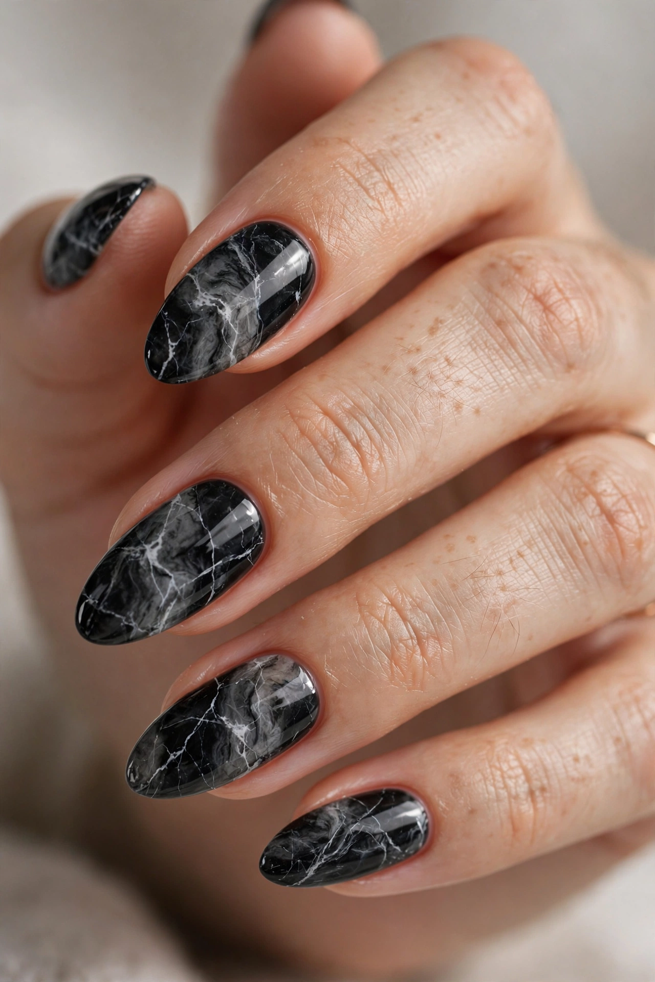 Black marble nail designs with white and gold veining like dark stone