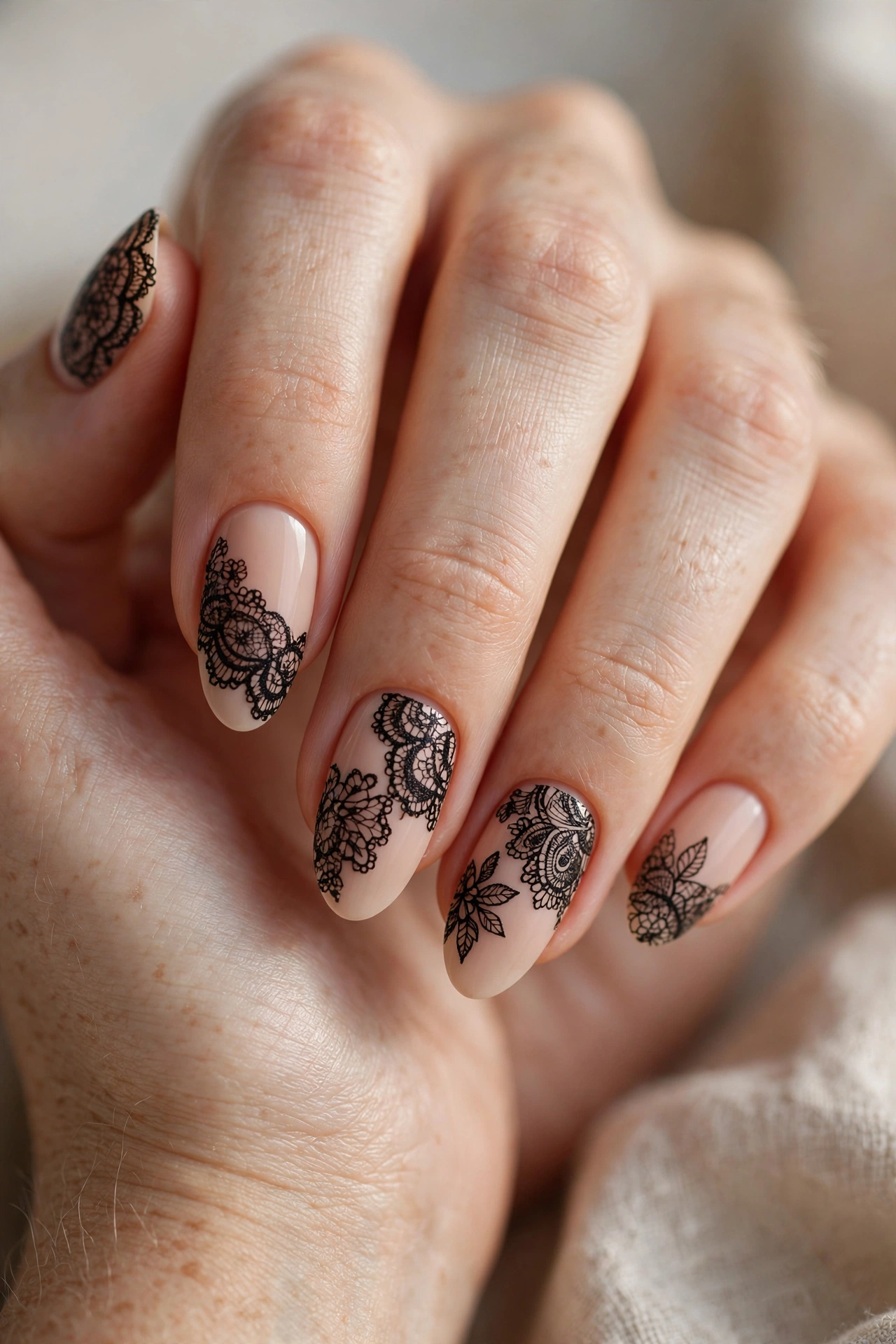 Black lace nail designs with delicate lace patterns over nude and black bases