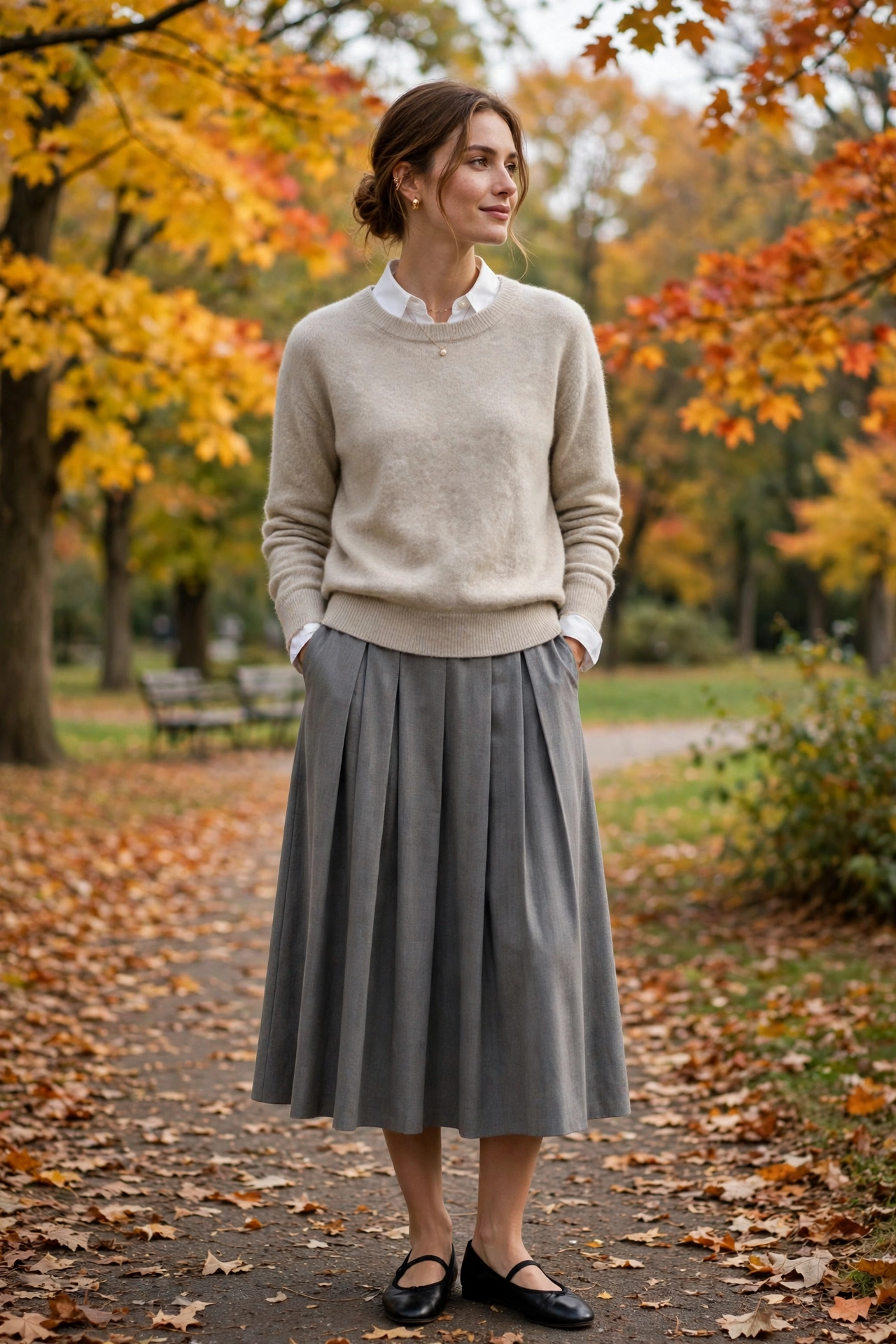 Woman in a navy cashmere crewneck with white jeans and loafers in autumn